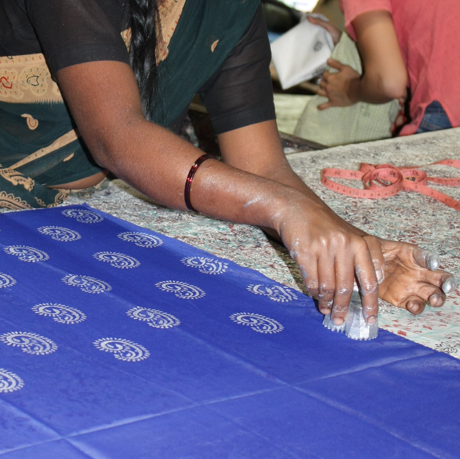 Hands block printing blue cloth in Halasur, Karnataka, India